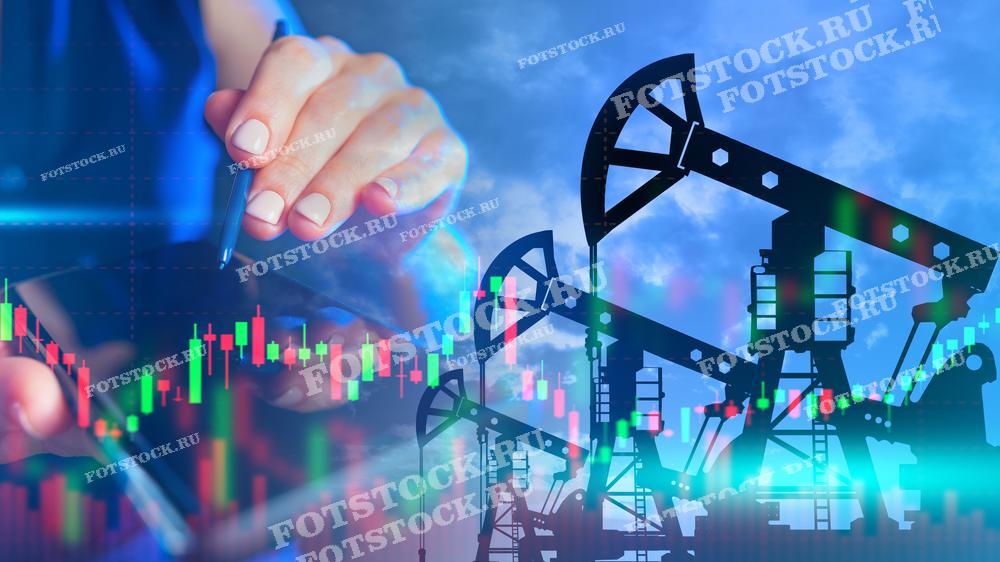 На фото изображены нефтяные вышки на фоне графиков, отображаемых на экране устройства. Это символизирует анализ и мониторинг рынка нефти, а также его колебания и тенденции.